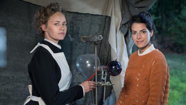 Clarissa (re.) erfährt von Marie Curie (Inez Bjørg David, li), wie ihre Röntgengeräte funktionieren.