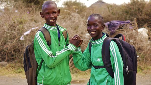 Gemeinsam rennen Bariki und Stephano jeden Morgen zur weit entfernten Schule. Dafür brauchen sie eine Stunde und abends die gleiche Zeit wieder zurück. Das ist ein tägliches Lauftraining für sie!