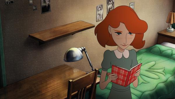 Kitty steht in einem Zimmer vor einem Schreibtisch und liest in Annes Tagebuch, das sie vor sich in den Händen hält.