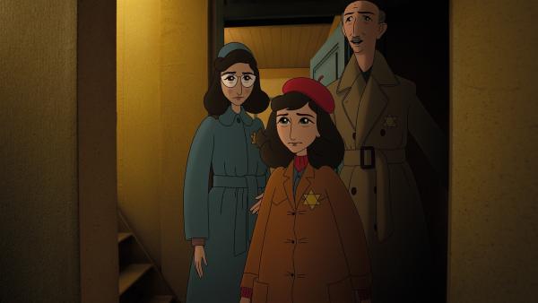 Anne steht mit ihrer Mutter und ihrem Vater im Treppenhaus eines Wohnhauses. Sie blicken traurig und besorgt.
