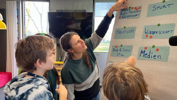 Auftakttreffen des Kinderredaktionsrates am 31.10.2025 beim Kinderkanal in Erfurt. Redakteurin Anne Reichenbach beim Workshop mit Margarete, Jonathan und Maggy. | Rechte: KiKA/Antje Stille